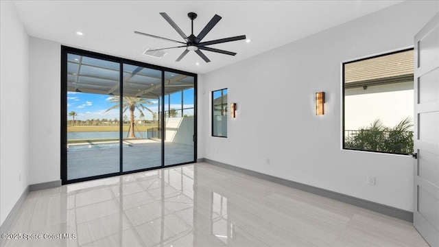 spare room with floor to ceiling windows, a water view, and ceiling fan