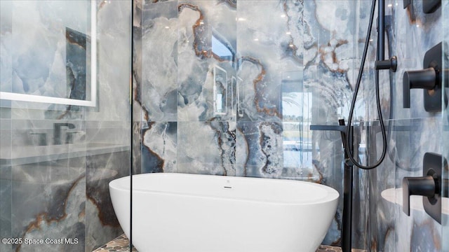 bathroom featuring a bath and tile walls