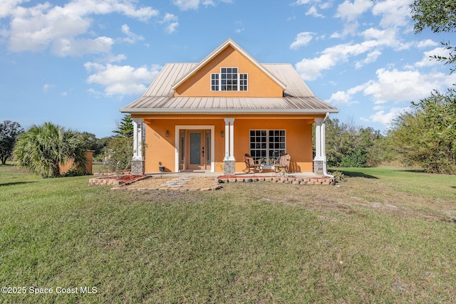 back of property with a lawn and a porch