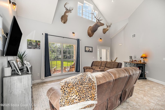 living room with light tile patterned floors and high vaulted ceiling