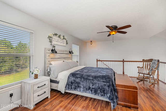 bedroom with ceiling fan, dark hardwood / wood-style floors, and a textured ceiling