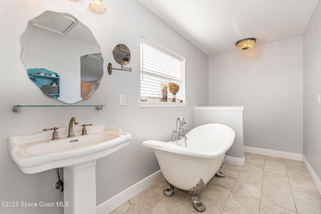 bathroom featuring a bathing tub, tile patterned flooring, and a textured ceiling