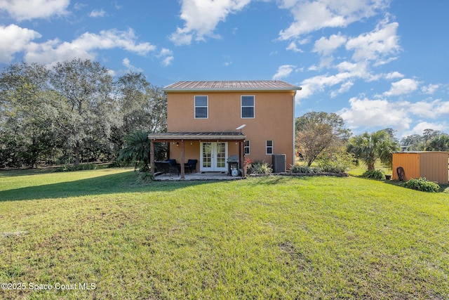 rear view of property with a lawn, central AC unit, and french doors