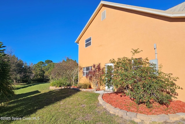 view of side of home with a yard