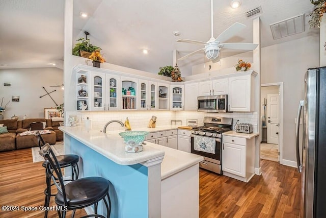 kitchen with kitchen peninsula, white cabinets, and appliances with stainless steel finishes