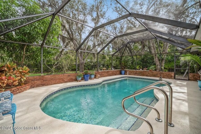 view of swimming pool with a patio area and a lanai