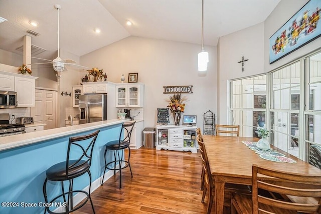 kitchen featuring appliances with stainless steel finishes, backsplash, ceiling fan, white cabinets, and hanging light fixtures