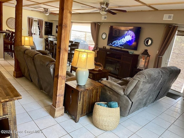 tiled living room featuring ceiling fan and a fireplace