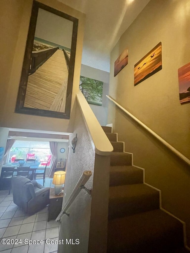 staircase featuring tile patterned flooring