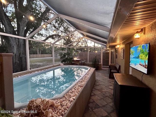 view of swimming pool with glass enclosure and a patio area