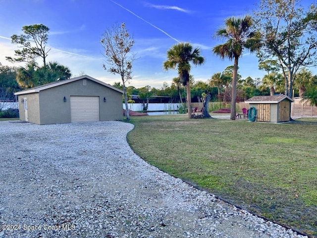 view of yard featuring a garage and a storage shed