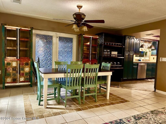 tiled dining space with ceiling fan and a textured ceiling