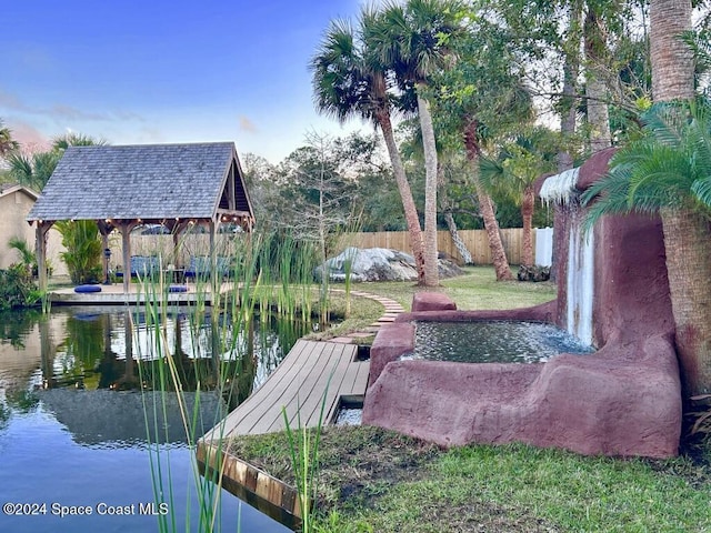 view of dock with a gazebo and a water view