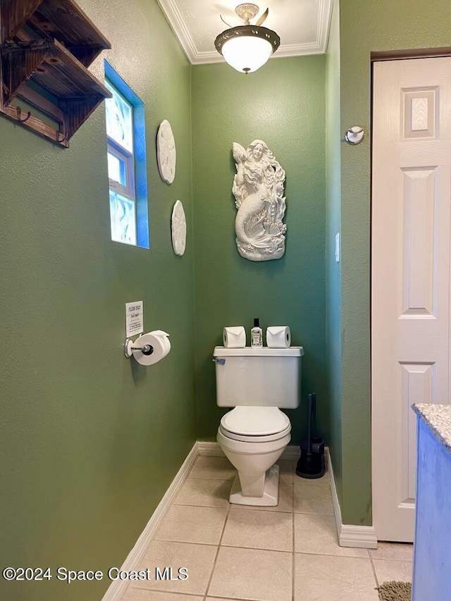 bathroom with tile patterned flooring, toilet, and crown molding