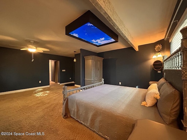 carpeted bedroom with ceiling fan and beamed ceiling