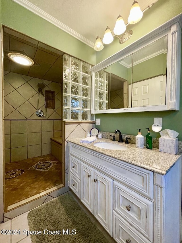 bathroom with tiled shower, vanity, tile patterned floors, and crown molding