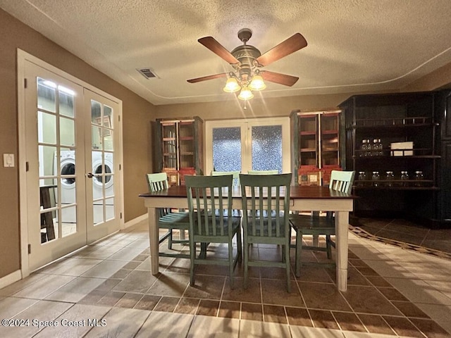 dining space featuring ceiling fan, washer / dryer, a textured ceiling, and french doors