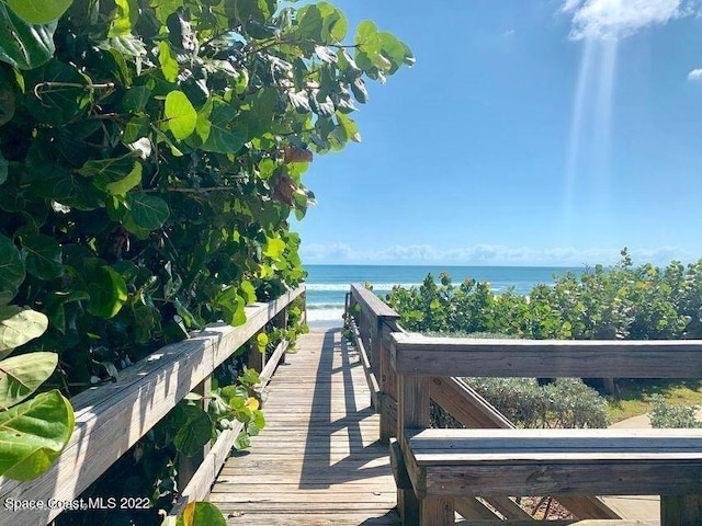 view of property's community featuring a water view and a beach view