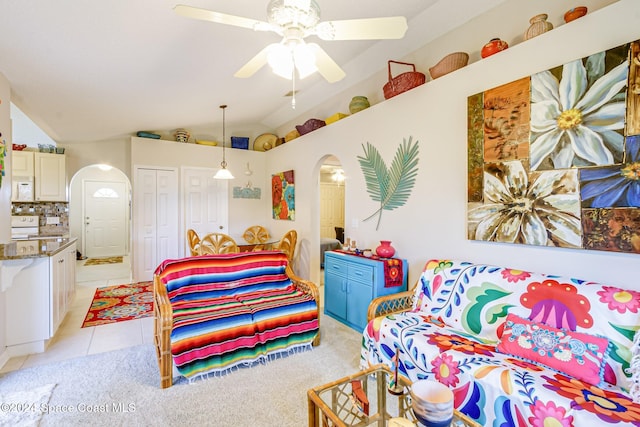 interior space featuring ceiling fan, lofted ceiling, and light tile patterned floors