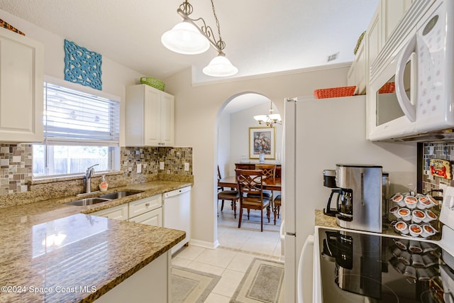 kitchen with white appliances, white cabinetry, pendant lighting, and sink