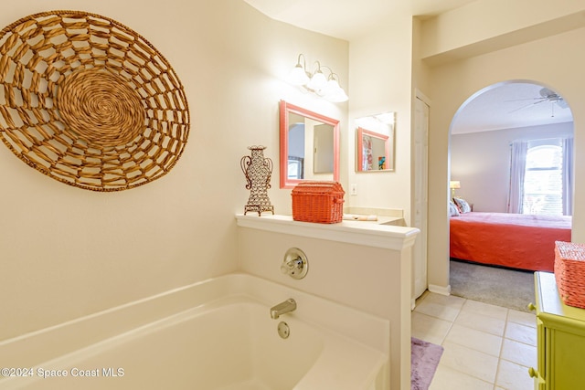 bathroom featuring ceiling fan, a tub to relax in, and tile patterned flooring