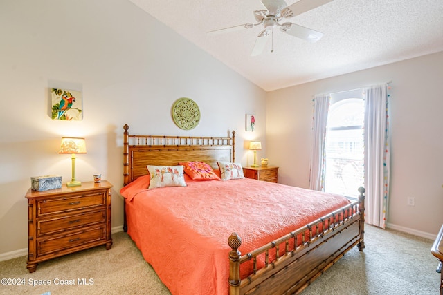 bedroom featuring a textured ceiling, light carpet, ceiling fan, and vaulted ceiling