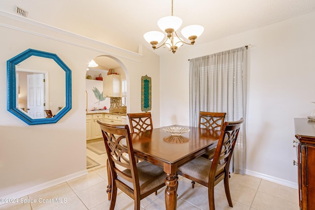 dining area featuring a notable chandelier and light tile patterned flooring