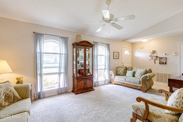 carpeted living room featuring a healthy amount of sunlight, ceiling fan, vaulted ceiling, and a textured ceiling