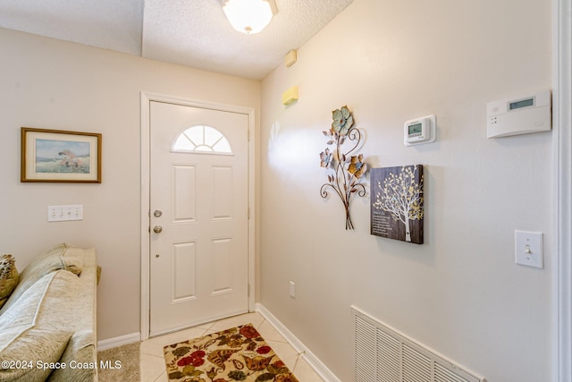 entrance foyer with light tile patterned flooring and a textured ceiling