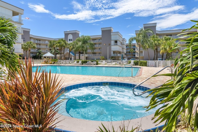 view of swimming pool featuring a hot tub