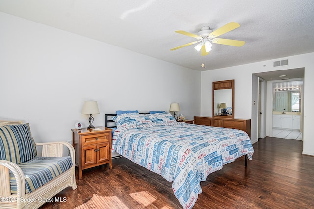 bedroom featuring a textured ceiling, ensuite bathroom, ceiling fan, and dark wood-type flooring