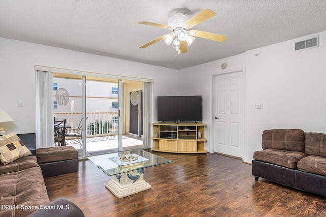 living room featuring ceiling fan, dark hardwood / wood-style flooring, and a textured ceiling