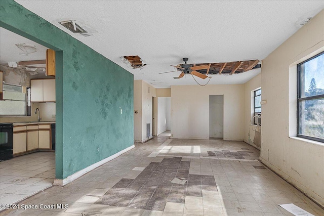 unfurnished room featuring a textured ceiling, ceiling fan, and sink