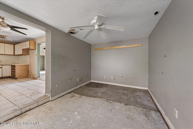 empty room with ceiling fan and a textured ceiling