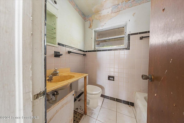 bathroom with sink, a bath, tile patterned floors, toilet, and tile walls