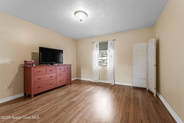 bedroom with wood-type flooring and a textured ceiling