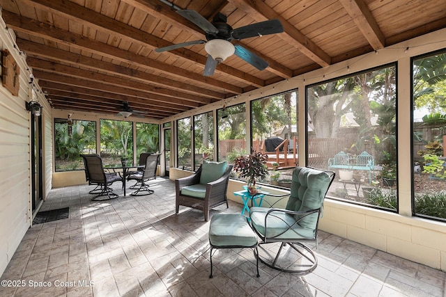 unfurnished sunroom with ceiling fan, beamed ceiling, and wood ceiling