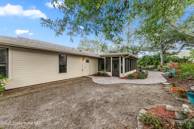 rear view of house featuring a sunroom