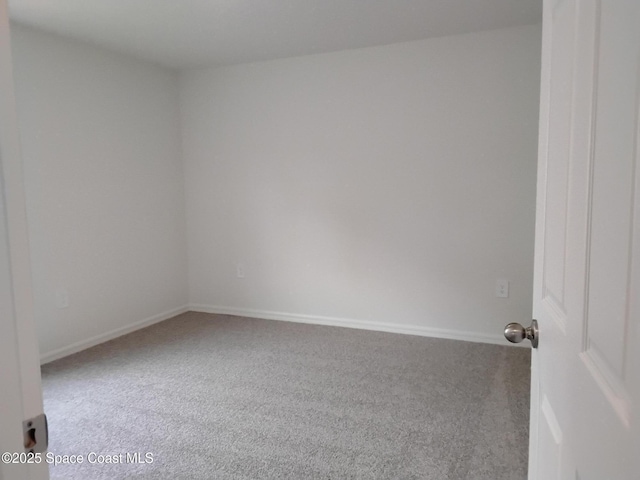 carpeted spare room with baseboards