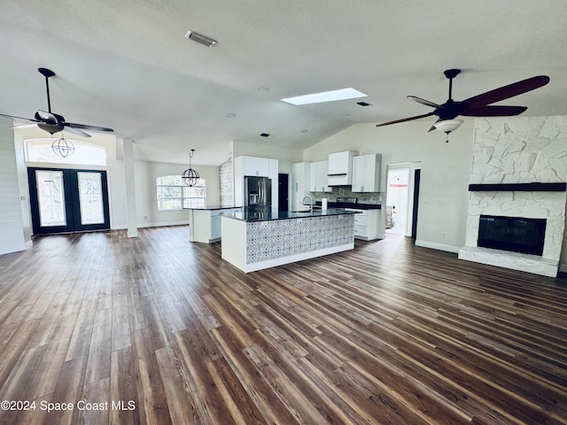 kitchen with a center island with sink, stainless steel fridge, backsplash, dark hardwood / wood-style flooring, and white cabinets