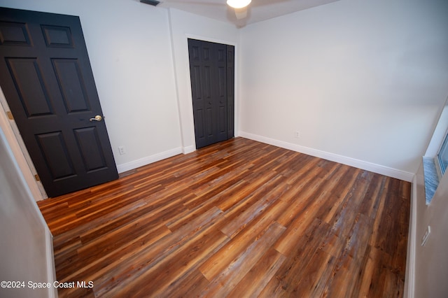 unfurnished bedroom with dark wood-type flooring