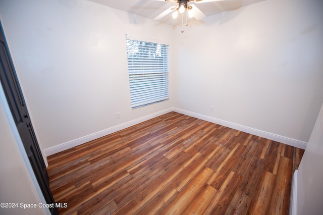 empty room featuring ceiling fan and dark wood-type flooring