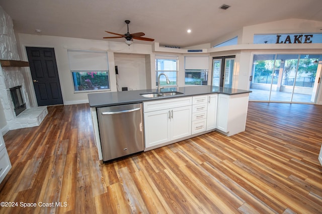 kitchen featuring dishwasher, white cabinetry, a fireplace, sink, and light hardwood / wood-style flooring