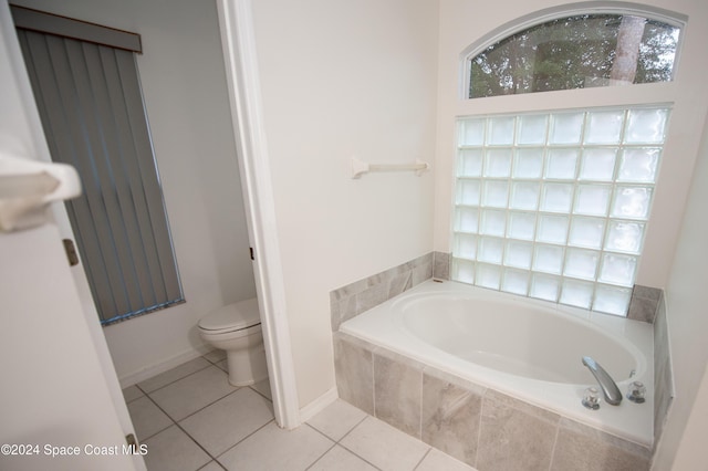 bathroom featuring toilet, tiled tub, and tile patterned floors