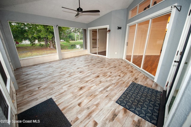 sunroom / solarium with ceiling fan and vaulted ceiling