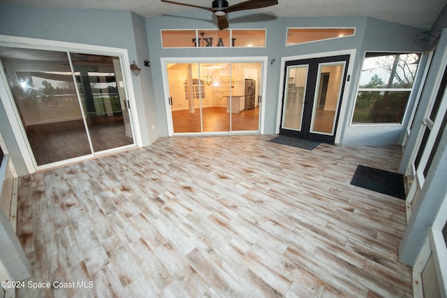 unfurnished sunroom featuring ceiling fan, french doors, and vaulted ceiling