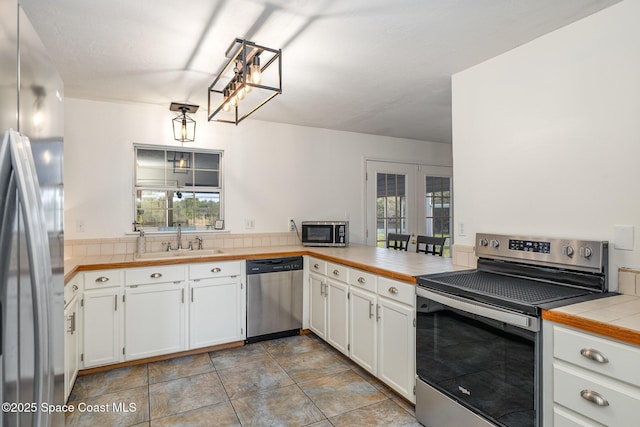 kitchen featuring white cabinets, appliances with stainless steel finishes, a healthy amount of sunlight, and sink