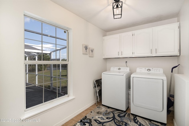 clothes washing area with light hardwood / wood-style floors, cabinets, and independent washer and dryer