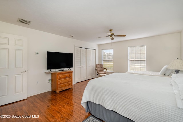 bedroom featuring ceiling fan, a closet, and dark wood-type flooring