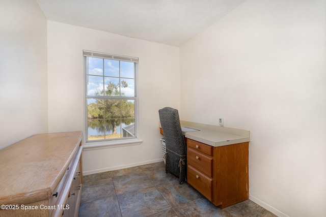 office space with a water view and a textured ceiling